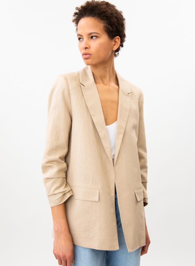 Con manga fruncida y bolsillos delanteros, esta blazer en color beige está confeccionada en una mezcla de lino y algodón y tiene un precio de 19,99 euros. Es de Lefties.