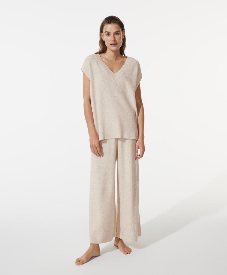 Este conjunto de punto en color crudo con tejido jaspeado está formado por un pantalón (35,99 euros) tobillero con patas anchas y una camiseta (25,99 euros) sin mangas con escote de pico.