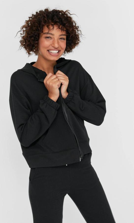 Disponible en otros colores, esta sudadera negra con capucha y cierre mediante cremallera es de Stradivarius y tiene un precio de 17,99 euros.