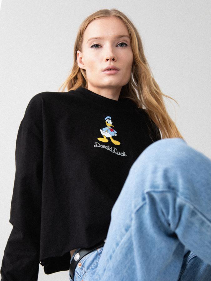 Para las que siguen en contacto con su lado más infantil, esta camiseta corta de manga larga en negro y con estampado del pato Donald cuesta 9,99 €.