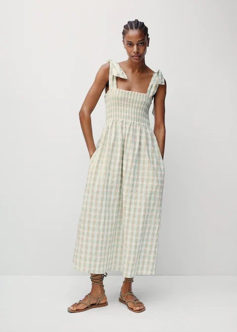 Vestido midi con estampado de cuadros vichy en color verde agua. Un diseño tendencia que no te vas a querer quitar en primavera y verano. Escote recto con panel fruncido, tejido de algodón y tirantes con lazada. ¡Pura monería! (39,99 euros).