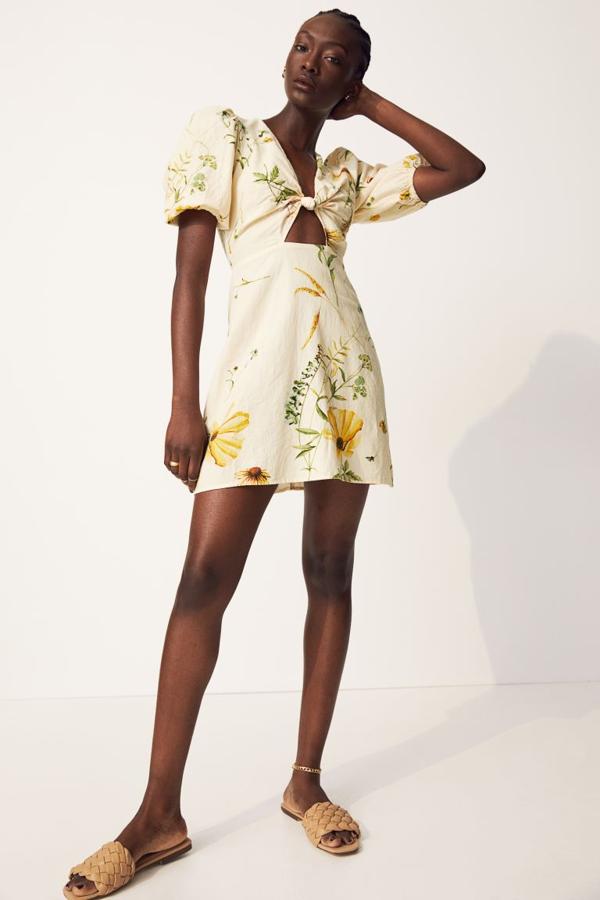 En H&M encontramos este favorecedor mini vestido de lino en amarillo vainilla con flores en amarillo más intenso y original escote rematado con nudo. Cuesta 24.99 euros.