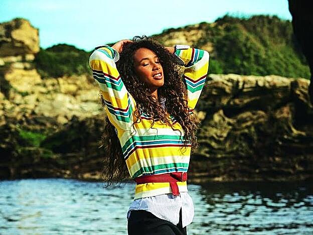 Canisa de Uniqlo, jersey de rayas y falda larga con godés, ambos de Louis Vuitton, y deportivas de Nike. Ane Yarza y José A. López