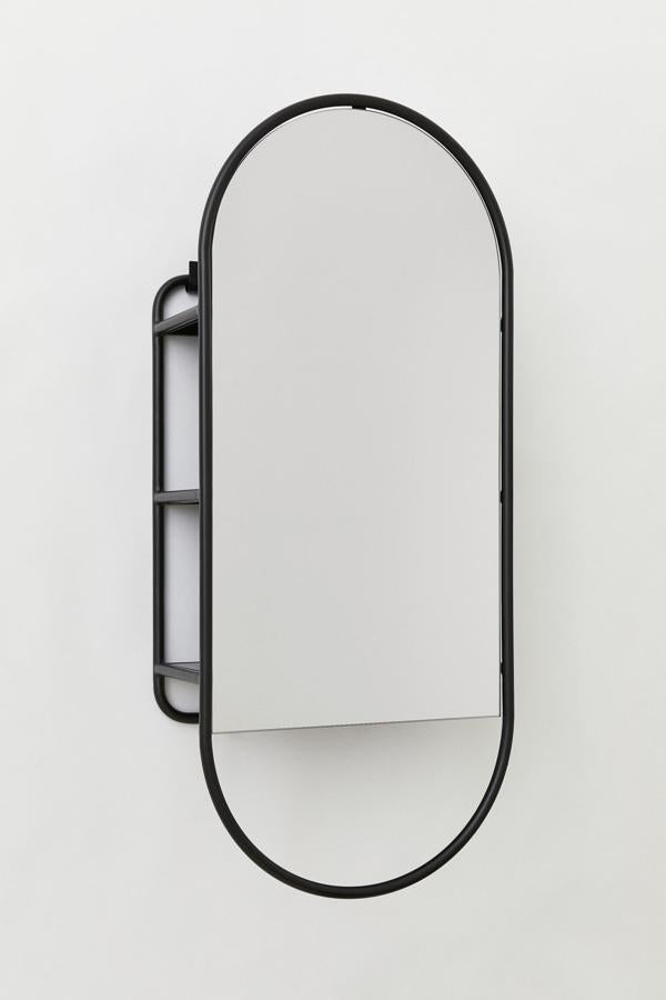 Este espejo grande con marco de metal pintado y parte superior redondeada cuenta con tres estantes ocultos en la parte posterior y tiene un precio de 179 euros.