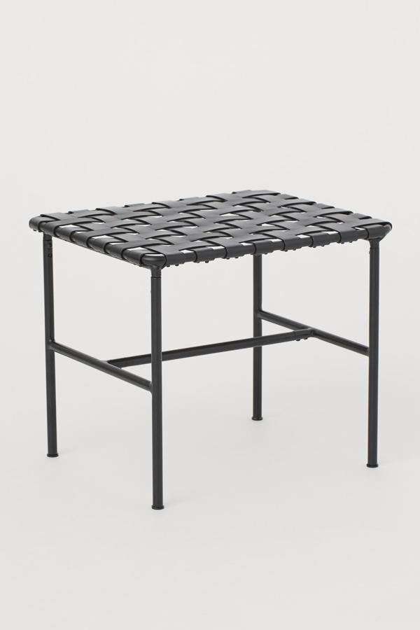 Con asiento de piel trenzada de color negro y marco en metal pintado, este original taburete tiene unas medidas de 40x40x47 centímetros y un precio de 129 euros.