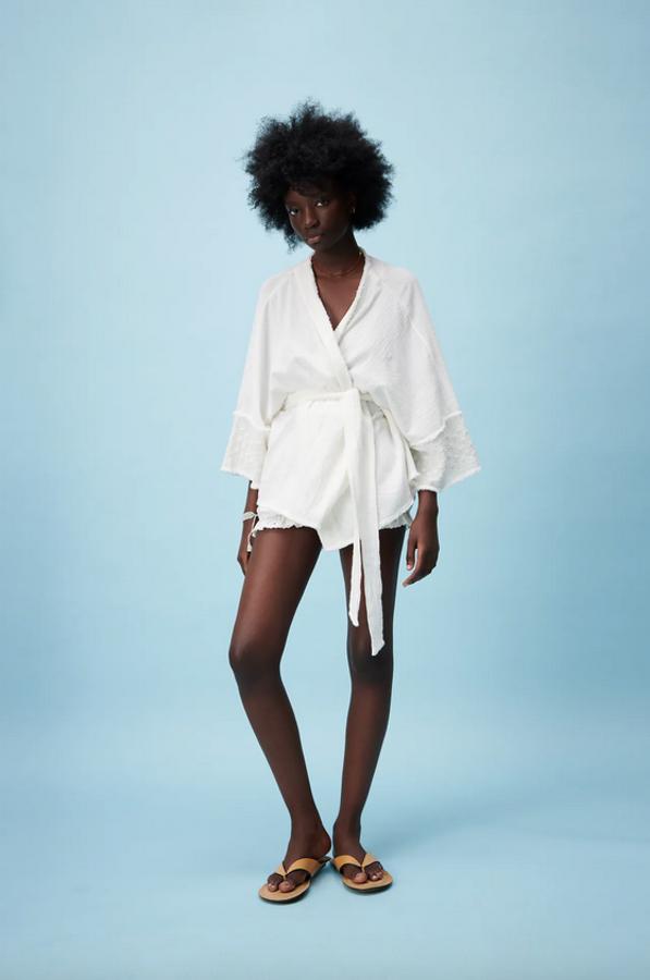 Diseño corto, escote de pico cruzado y manga amplia por debajo del codo para este kimono en color crudo con detalles de bordados combinados a tono en las mangas y cinturón tipo lazada en el mismo tejido. Está disponible en las tallas XS-S y M-L y cuesta 29,95 euros.