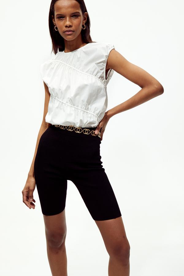 En blanco, con cuello caja y diseño de gomas cruzadas en la prenda de algodón 100%, este top bimateria cuesta 23,99 euros y está disponible en las tallas S y M.