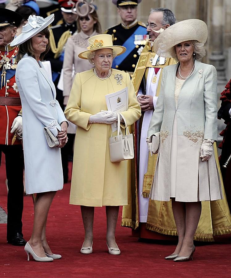 La reina Isabel II escogió un abrigo y sombrero amarillos (desafiando a las supersticiones) con flores de seda de Angela Kelly. Camila Parker Bowles iba vestida por Anne Valentine, muy fiel a su estilo con un abrigo de tonos empolvados, complementado con guantes y pamela. La madre de la novia, Carole Middleton apostó por un diseño en azul bebé y pamela. Muy elegante.