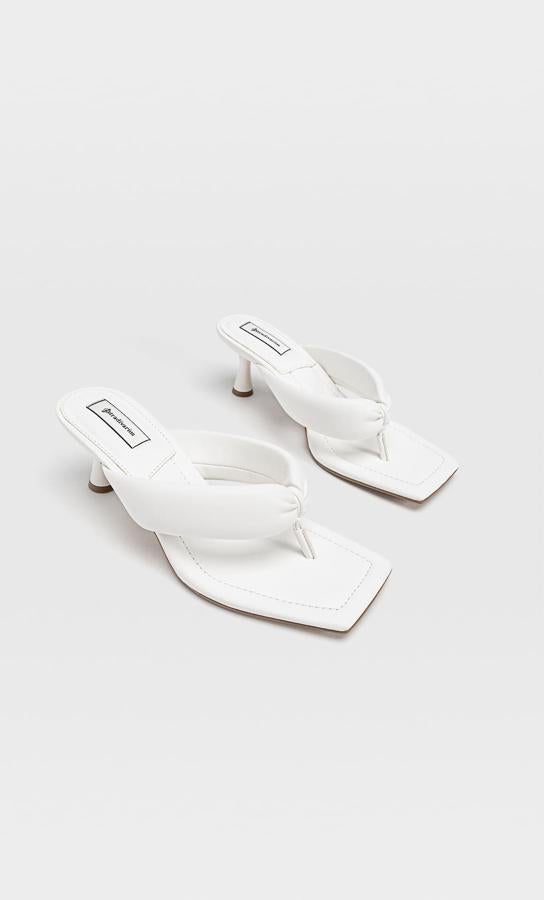 Con tiras acolchadas con detalle de posición para el dedo, estas sandalias blancas de Stradivarius con tacón de 6,5 centímetros tienen un precio de 29,99 euros y podemos encontrarlas entre los números 35 y 41.