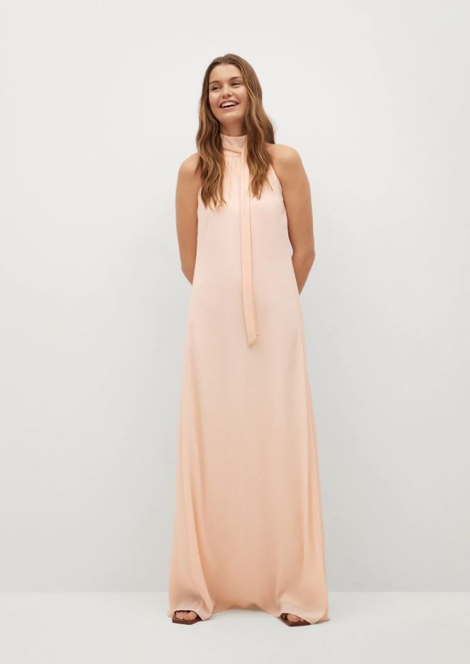 Maxi vestido de gasa en color melocotón con cuello halter, rebajado a 59.99 euros en las mid season sales de Mango.