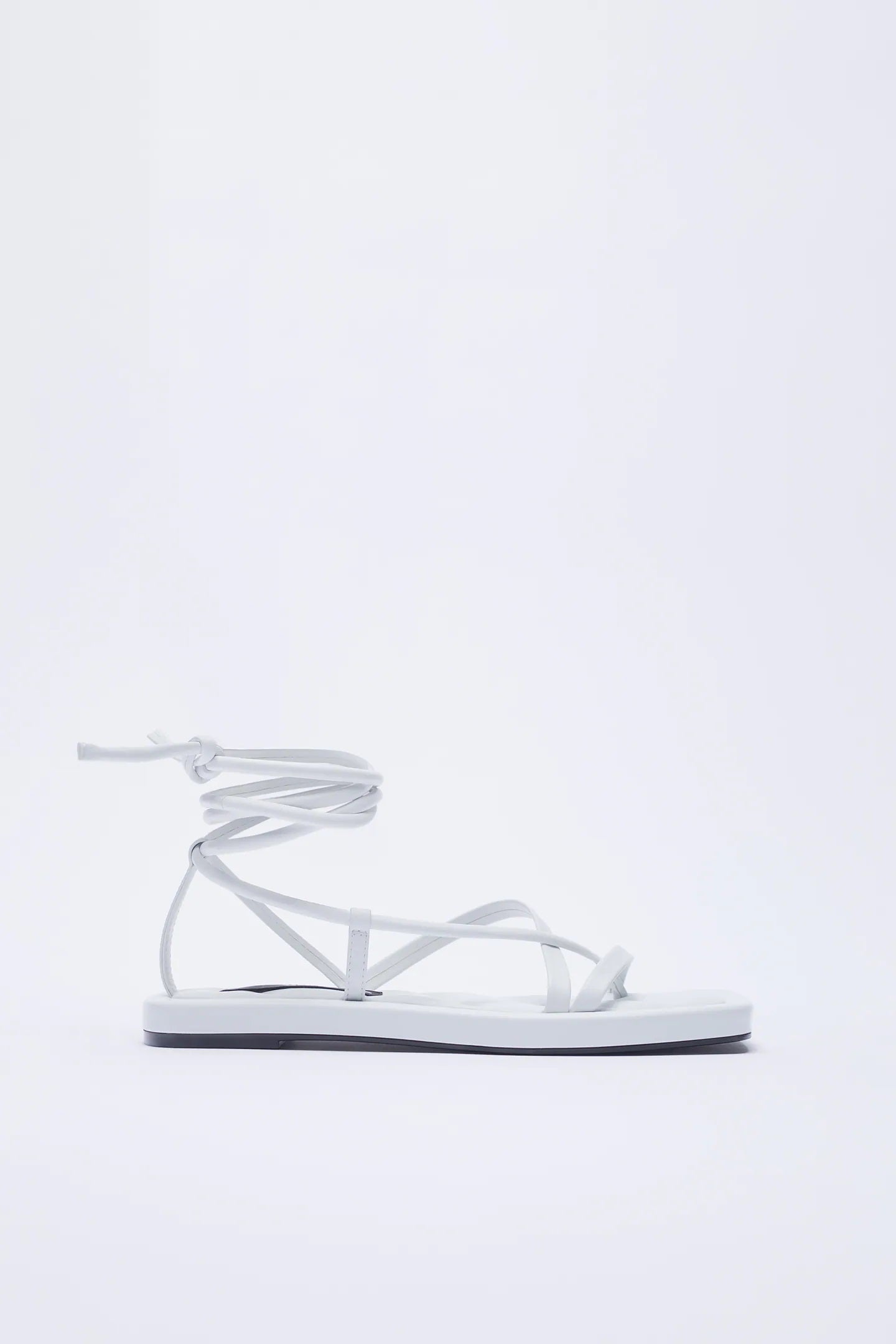 De piel, con tiras cruzadas y atadas al tobillo, y una suela de 2 cm super estilizadora. Ficha estas sandalias blancas de Zara para tu fondo de armario. (59,95 euros).