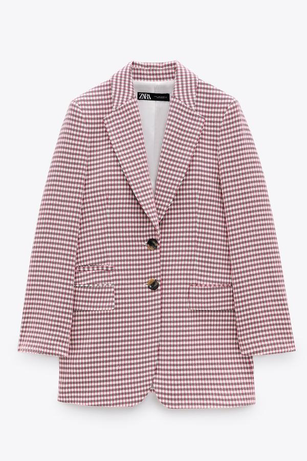 Con cuadros en color rosa chicle, esta blazer con manga larga acabada en botón y hombros marcados cuenta con cierre mediante botones metálicos y tiene un precio de 39,99 euros. Es de Stradivarius.