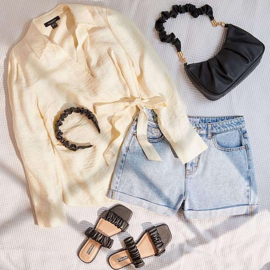 Consigue un look muy sofisticado con shorts vaqueros combinándolos con una blusa de satén súper favorecedora como esta con lazo. Los complementos acolchados ponen el toque de tendencia.