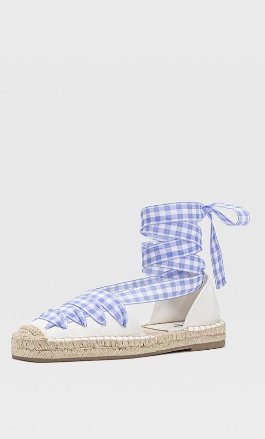 Con detalle de tiras con estampado de cuadros vichy en azul o beige, estas alpargatas son de Stradivarius y tienen un precio de 25,99 euros.