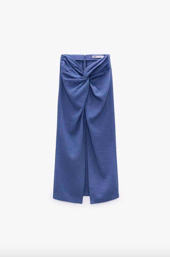 El azul es uno de los tonos estrella de la temporada y en esta falda confeccionada en tejido con textura llega en un tono medio, con tiro alto y detalle de nudo y abertura en delantero. El cierre está en la espalda, con cremallera oculta, y cuesta 25,95 euros. Solo queda en las tallas XS y XL.