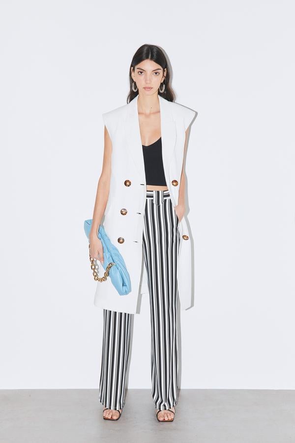 Chaqueta larga sin mangas, crop top y pantalones de rayas, todo de Sfera.