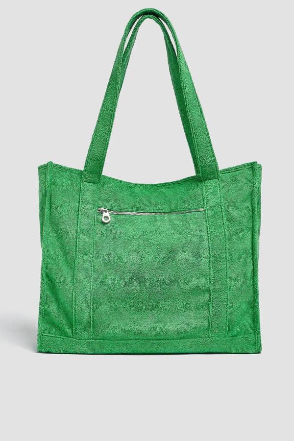 Con un llamativo color verde y tejido efecto toalla, este bolso shopper cuenta con asas de hombro y cierre mediante frunce. Tiene un precio de 22,99 euros.