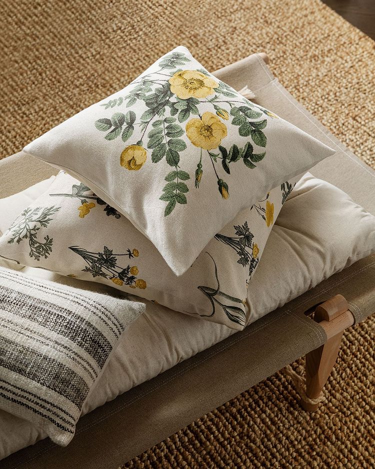 Estos alegres cojines con estampado de flores en color amarillo y verde cuestan 7.99 euros en H&M Home.