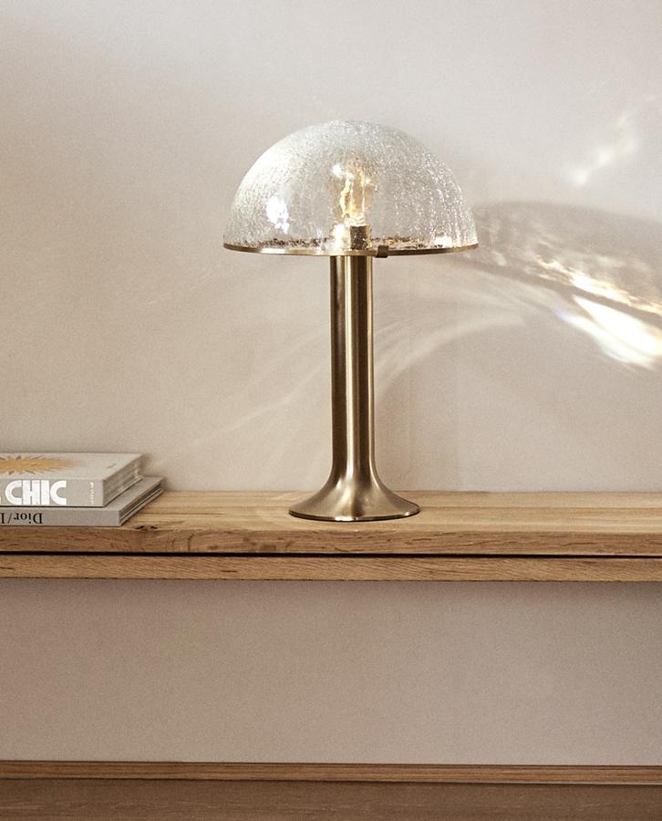 Con base de metal en dorado y una pantalla de cristal craquelado, esta lámpara de mesa con una altura de 45 centímetros y un ancho de 15 tiene un precio rebajado de 79,99 euros (antes 99,99 euros).