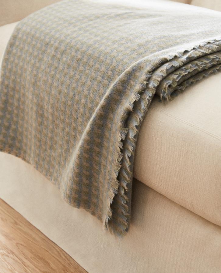 Disponible en azul verdoso o en beige, esta manta ligera con estructura de cuadros y acabado de flecos tiene una medida de 140x190 centímetros y un precio rebajado de 31,99 euros (antes 39,99 euros).