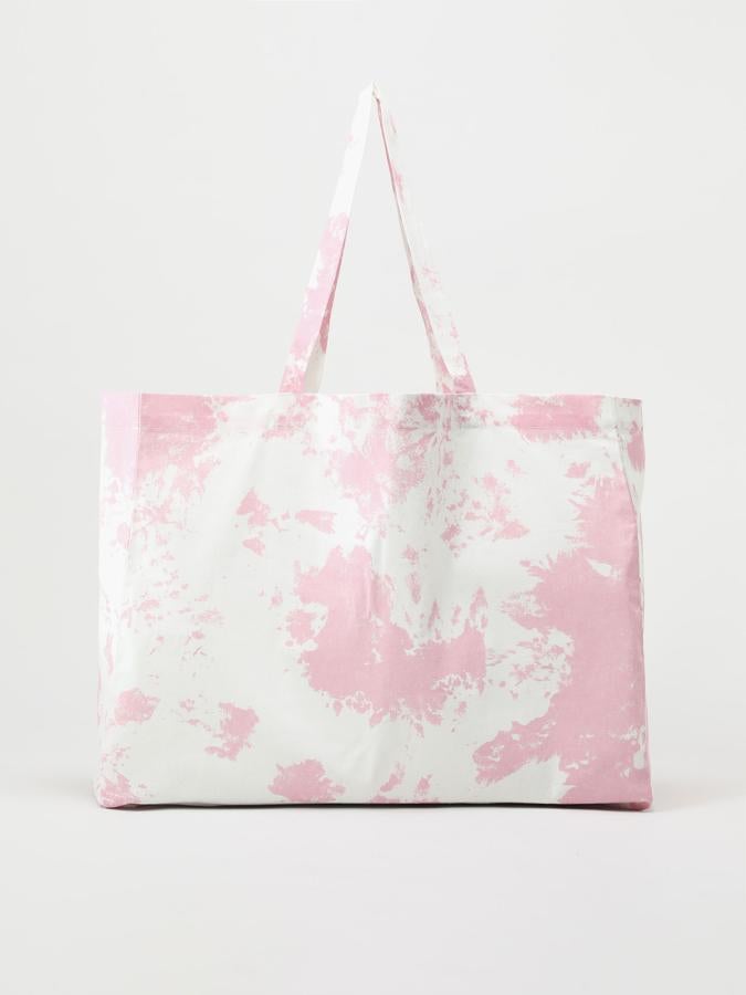 Este bolso formato shopper con estampado tie dye disponible en varios colores cuenta con asa de hombro del mismo tejido y tiene un precio de 5,99 euros.
