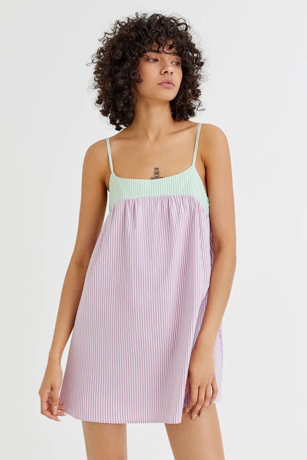 Con rayas verticales en color lila este vestido mini con escote redondeado y en popelín tiene un precio de 17,99 euros.