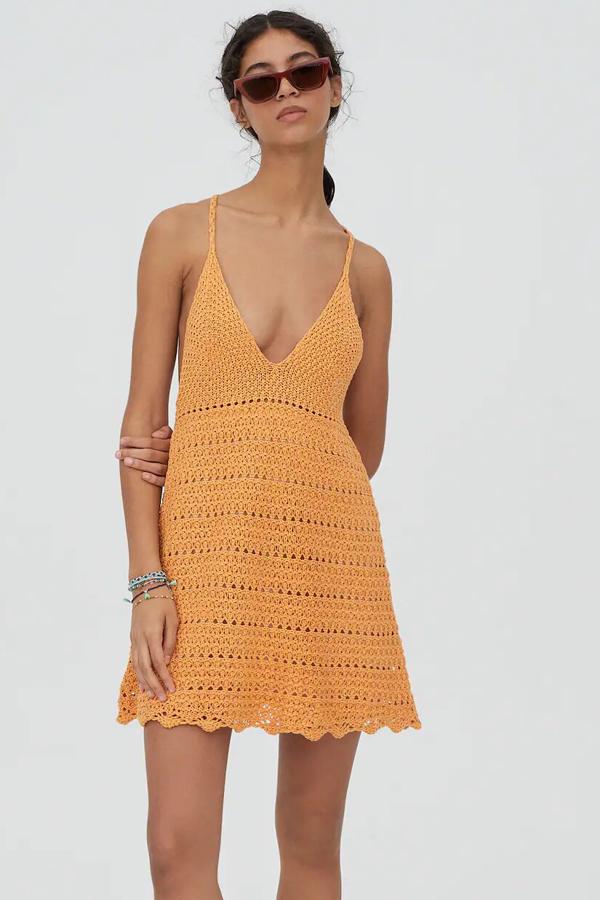 Disponible en naranja o en crudo, este vestido mini de crochet con escote de pico y tirantes finos tiene un precio de 22,99 euros.