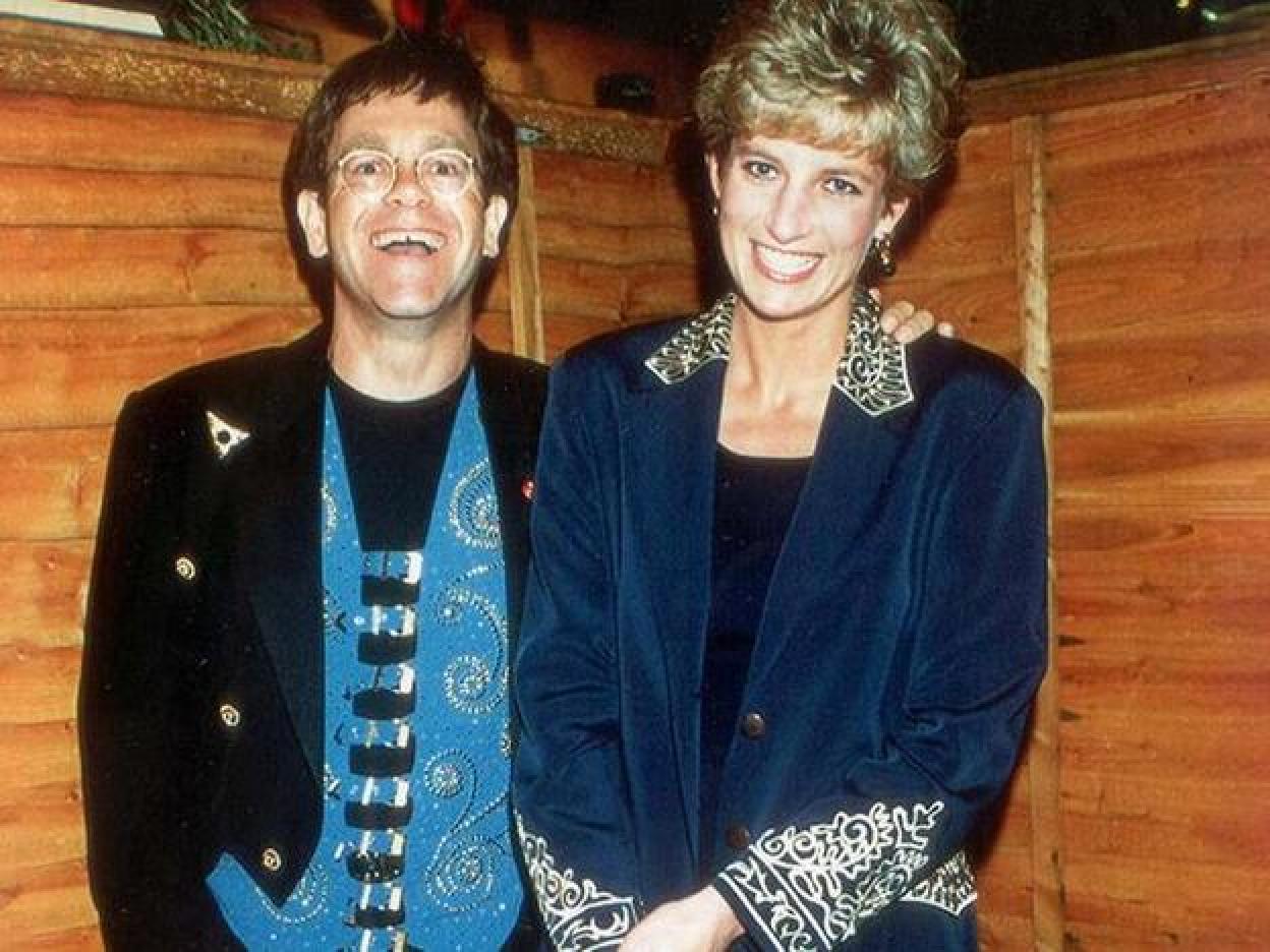 Elton John y la reina Isabel II en un acto. Si quieres ver la vida de la reina Isabel II en imágenes, pincha en la foto.