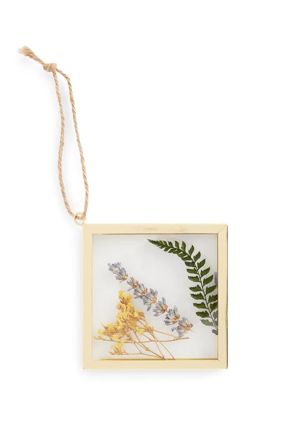 Con marco dorado, este marco pequeño para colgar con interior de flores prensadas tiene un precio de 2,5 euros.