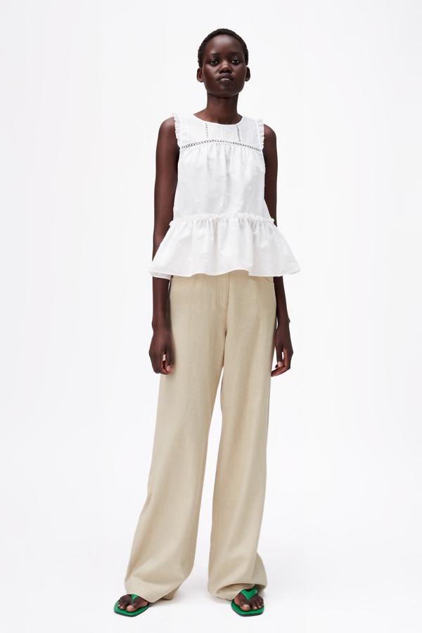 Blusa sin mangas con volante y pantalón ancho de pinzas, todo de Zara.