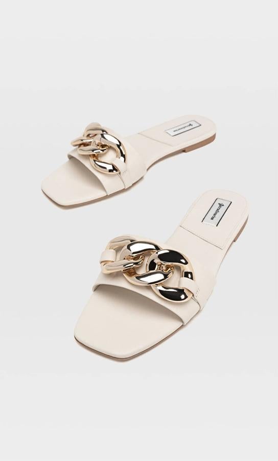 Disponibles en crudo o en negro, estas sandalias planas con detalle de cadena en la parte delantera son de Stradivarius y tienen un precio de 25,99 euros.