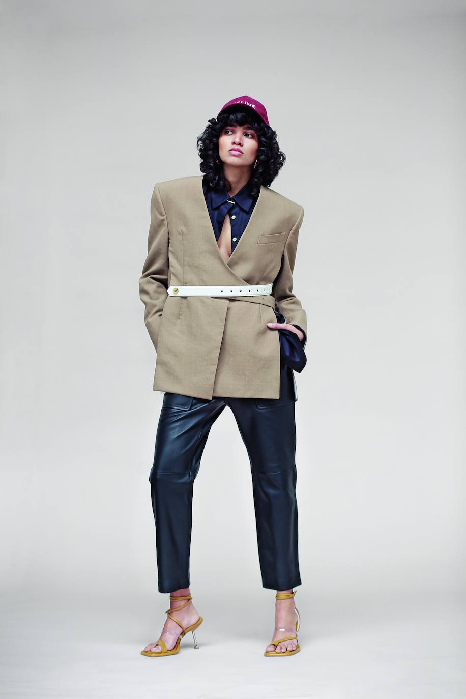 Americana con cinturón, de Louis Vuitton; camisa de Esaú Yori y pantalones de cuero, de Uterqüe. Gorra de Celine by Hedi Slimane y sandalias de Sportmax.