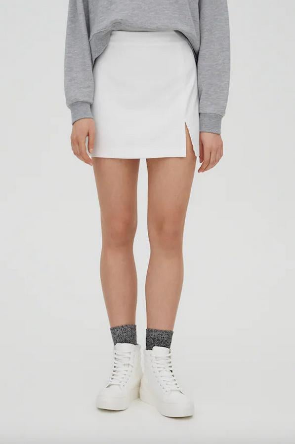 Con abertura delantera lateral y cierre de cremallera, esta minifalda blanca de Pull&Bear tiene un precio de 14,99 euros y está disponible entre las tallas XS y XL.