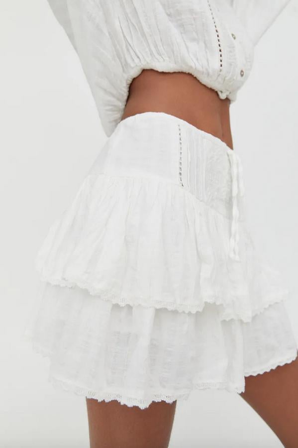 Con detalle de bordados en los volantes, esta minifalda blanca de cintura elástica confeccionada en algodón y viscosa tiene un precio de 17,99 euros y está disponible entre las tallas S y XL.