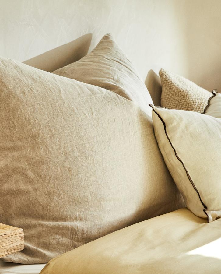 Los tejidos en lino no deben faltar en cualquier casa, y menos en esta si queremos que adquiera un aspecto similar al de este hotel. Apuesta por una roma de cama con cojines grandes y en formato XXL como este de Zara Home por 29,99 euros.