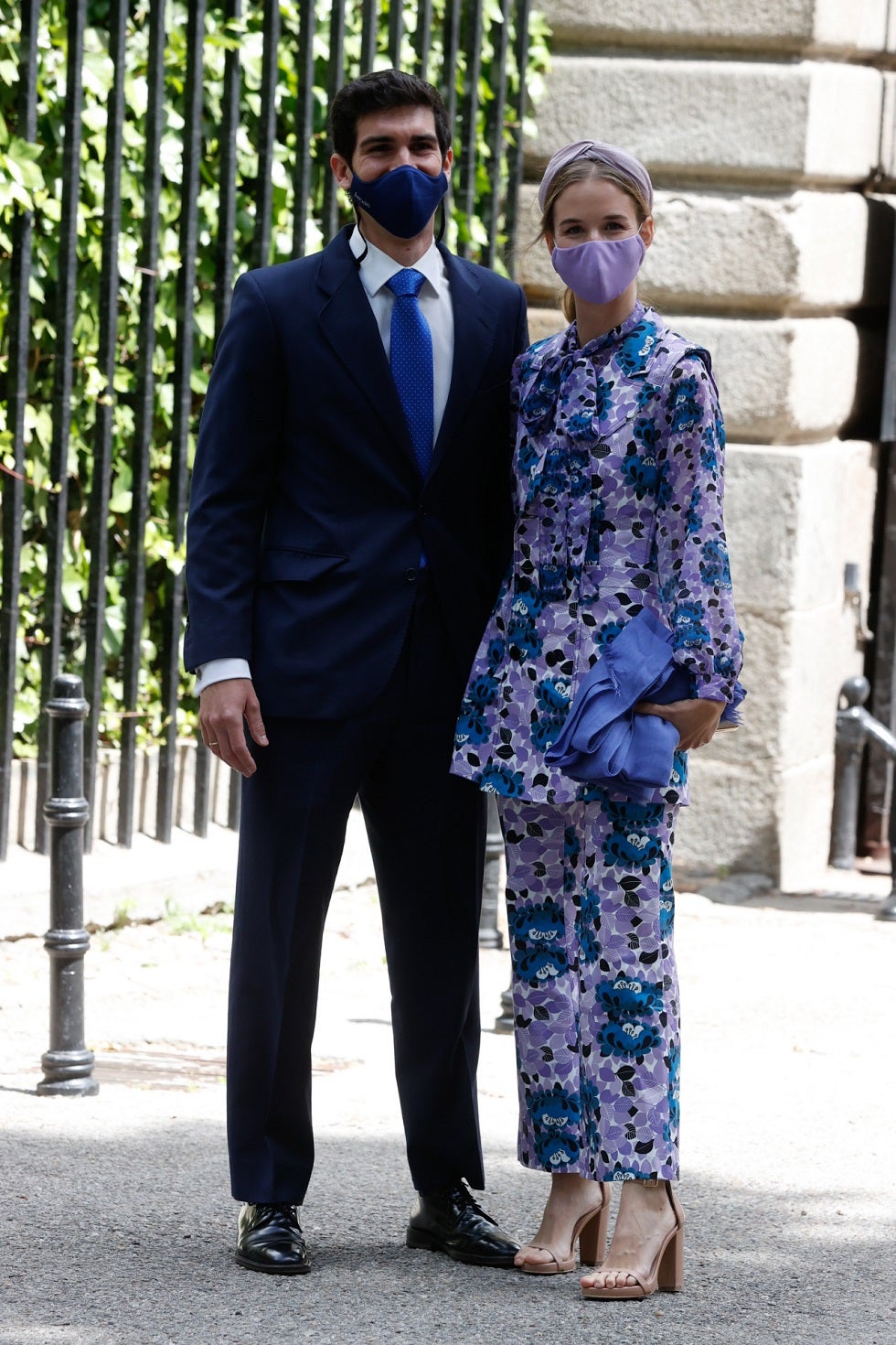 Alejandra Corsini, prima de la novia, junto a su marido. Look de invitada en traje estampado de dos piezas y tonos lilas.