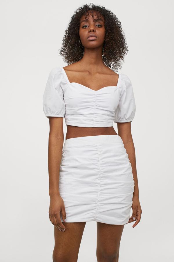 Disponible en blanco o en verde, esta falda drapeada con talle alto y costura fruncida en la parte delantera y lateral tiene un precio de 9,99 euros.