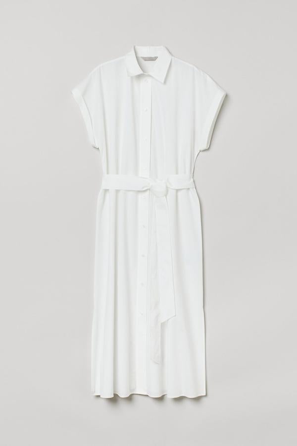 Este vestido camisero de color blanco cuenta con cinturón de anudar extraíble y aberturas laterales. Con mangas cortas, tiene un precio de 34,99 euros.