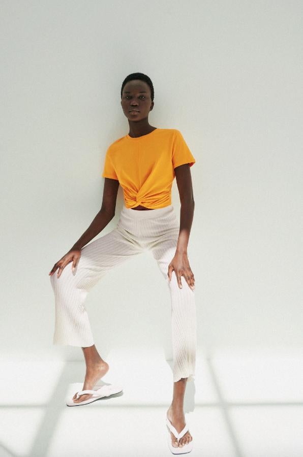 De cuello redondo y manga corta, esta camiseta confeccionada con al menos un 50% de algodón orgánico viene en cuatro colores, negro, blanco, naranja y rosa y tiene detalle de nudo frontal. Podemos encontrarla en las tallas S, M y L por 5,95 euros.