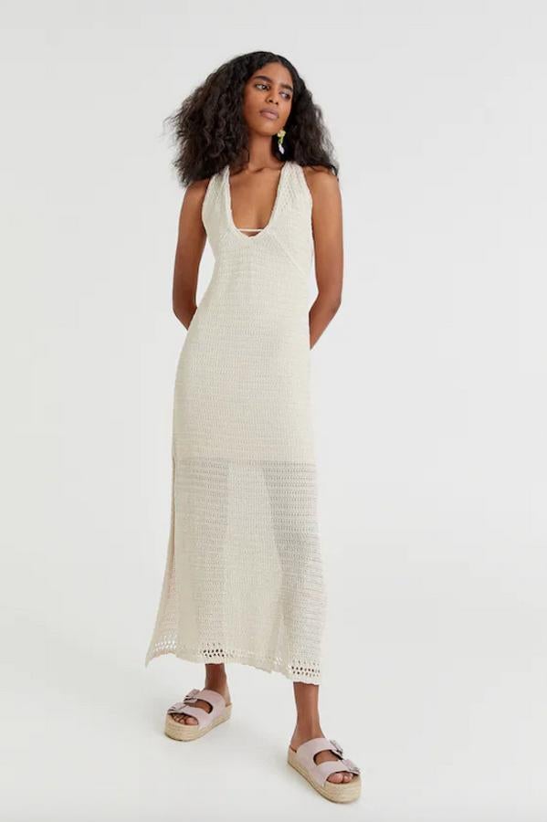Diseño largo en color crudo para este vestido de Pull&Bear en crochet y con tirantes con la espalda cruzada. Con escote con detalle de tira, aberturas frontales en el bajo y forro interior a tono, podemos encontrarlo entre las tallas XS y L por 29,99 euros.