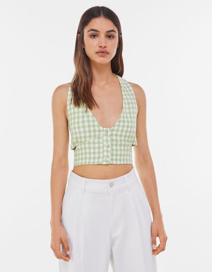 Chaleco corto con escote de pico, de Bershka (19,99 €).