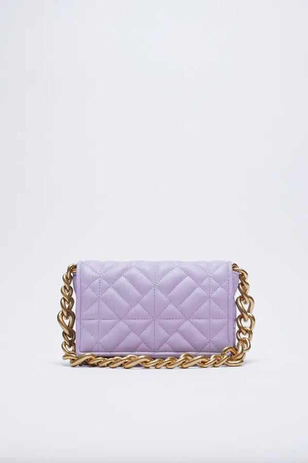 Diseño acolchado con asa de hombro con cadena gruesa para este bolso de Zara con interior forrado con bolsillo y cierre de solapa con imán. Tiene un precio de 22,95 euros.