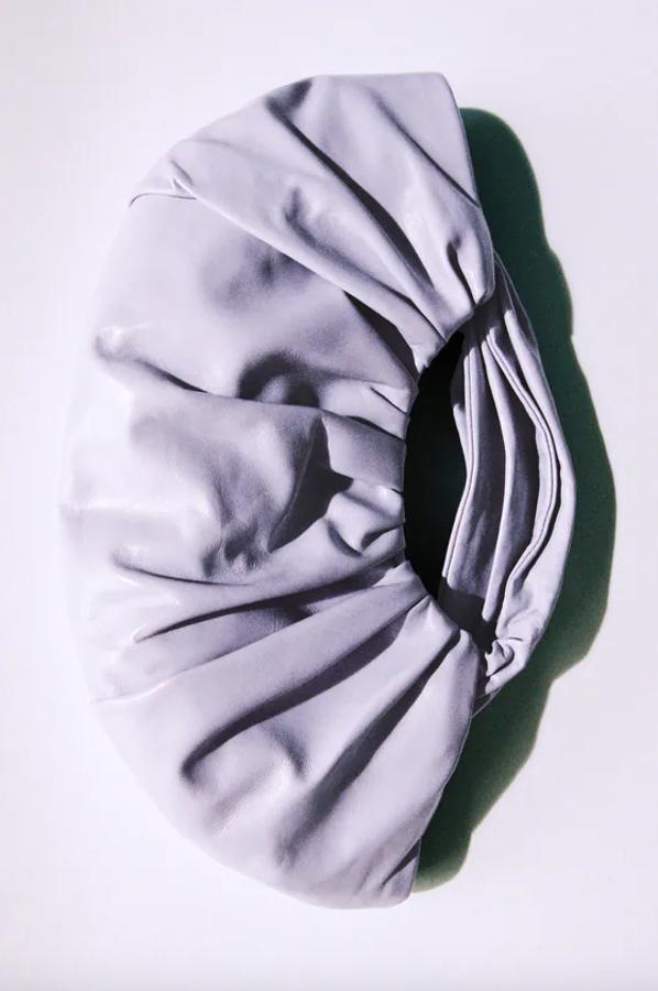 Este bolso de mano de Zara en formato saca con cuerpo fruncido y asas de mano viene con interior forrado y cierre mediante imán. Podemos comprarlo por 79,95 euros.