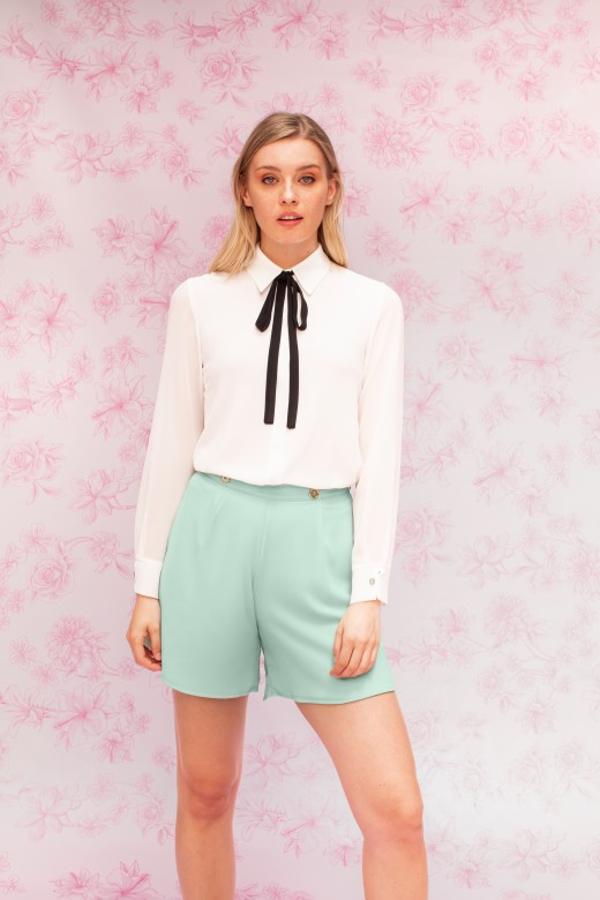 Blusa fluida, de doble capa, manga larga y cuello camisero con lazada intercambiable, en color negro y en su color (69 euros).