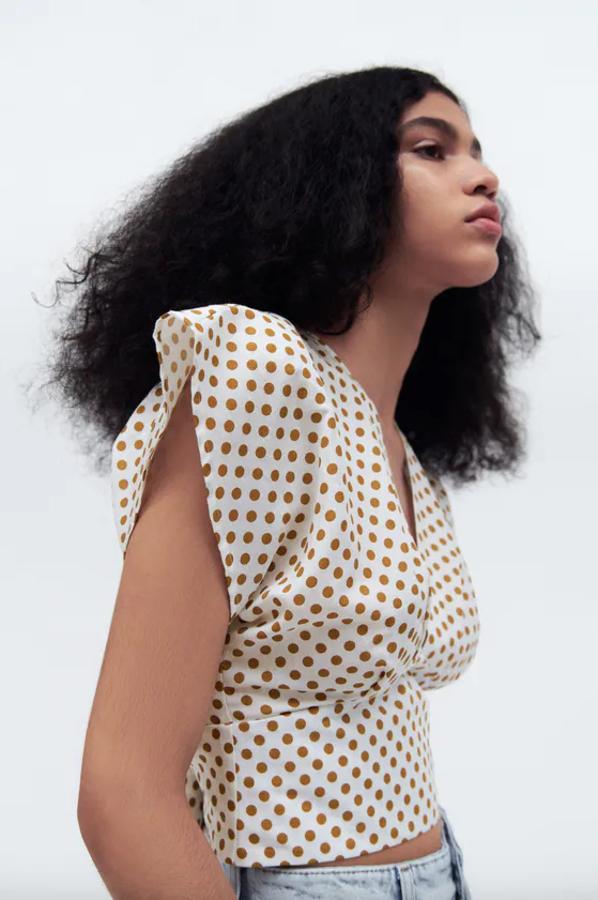 Confeccionada con al menos un 50% de lino europeo, esta blusa con escote de pico y manga corta con detalle de pliegues en delantero es de color blanco con lunares en mostaza. Con cierre de espalda con abertura y lazada, cuesta 22,95 euros y está disponible entre las tallas XS y L.
