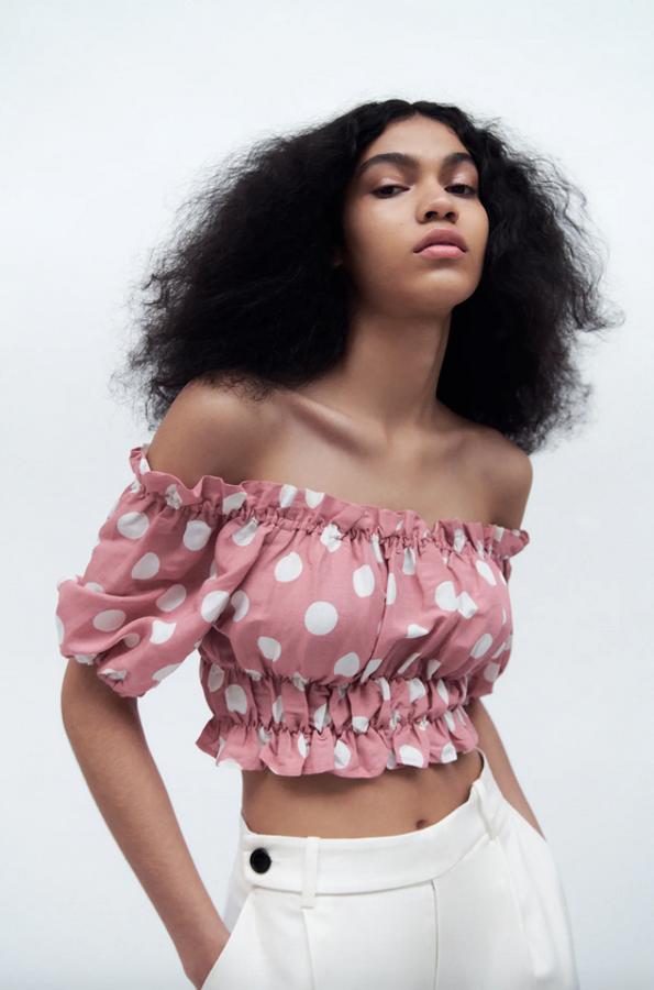 Confeccionado en mezcla de lino, con escote recto y manga corta abullonada, este top cropped de color rosa con lunares blancos tiene el bajo acabado en volantes y un precio de 19,95 euros. Solo queda en la talla S.