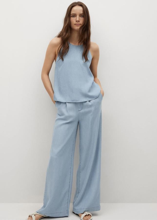 Con detalle de pinzas en la parte delantera y tiro alto, este pantalón en azul y con diseño acampanado cuenta con bolsillos laterales y trabillas. Es de Mango y tiene un precio de 29,95 euros.