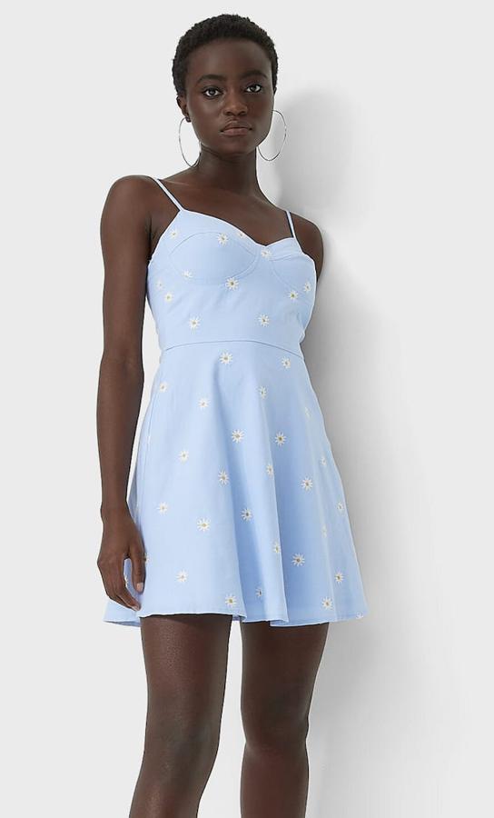 Es vestido corto en color azul celeste y con pequeñas flores bordadas cuenta con escote corazón y tirante fino. Con detalle de copas en el pecho, es de Stradivarius y tiene un precio de 25,99 euros.