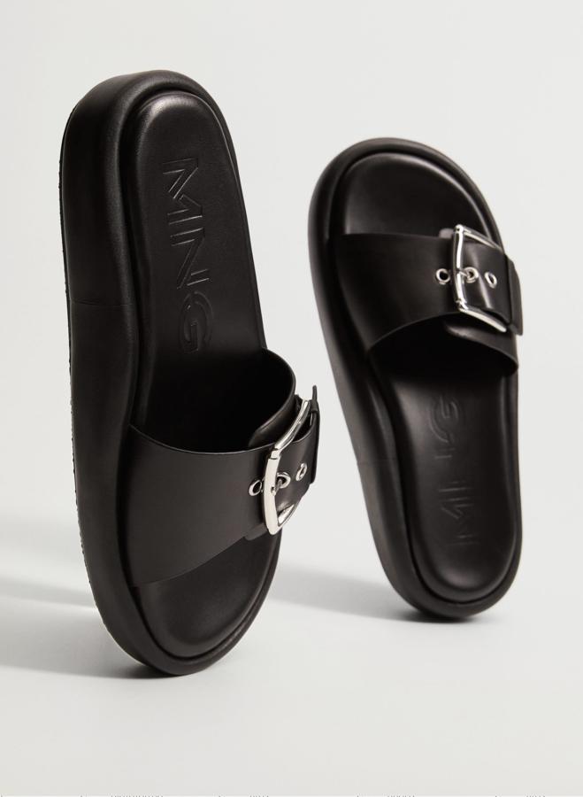 En color negro, esta sandalia de piel 100% bovina y punta redonda cuenta con plataforma y hebilla ajustable. Tiene un precio de 39,99 euros.