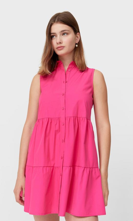 Disponible en fucsia o en blanco, este vestido camisero con manga sisa cuenta con cierre delantero con botones y tiene un precio de 15,99 euros.